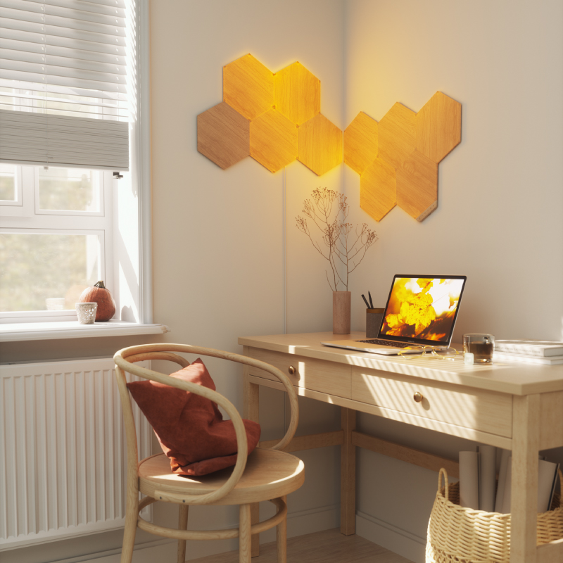 Nanoleaf Elements Thread enabled wood look hexagon smart modular light panels flex linkers mounted to a wall in a home office. HomeKit, Google Assistant, Amazon Alexa, IFTTT.