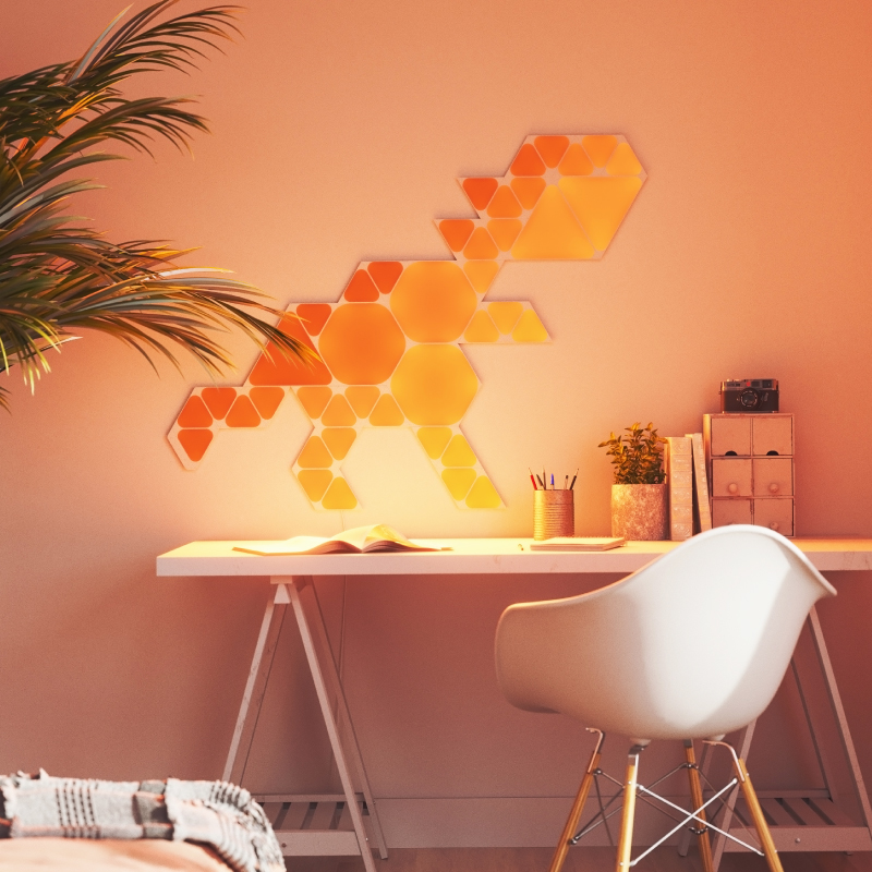 Nanoleaf Shapes Thread enabled color changing mini triangle smart modular light panels mounted to a wall above a desk. Similar to Philips Hue, Lifx. HomeKit, Google Assistant, Amazon Alexa, IFTTT.